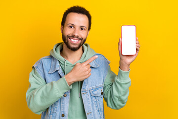 Photo of young handsome promoter guy wear waistcoat direct finger menu advert recommendation phone isolated on yellow color background