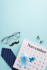 Men's Health Month theme. Top view vertical image of prostate cancer blue ribbons, calendar, tie,...