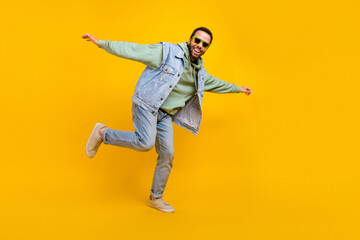 Fototapeta na wymiar Full length size body cadre freedom careless guy hipster style youth denim style outfit dancing isolated on bright yellow color background