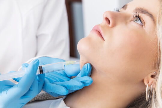doctor with a syringe injecting patient with botox