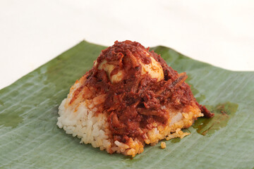 Nasi lemak wrapped with banana leaf isolated on white background.