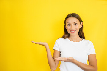Woman Pointing Sideways on Yellow Background Copy Space