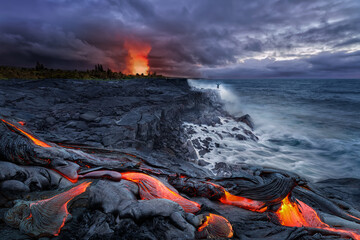 Close-up of lava flowing from a rock column and pours into a volcanic landscape. Lava flow at Kalapana beach after sunset with an explosive eruption of the Kilauea volcano at Big Island Hawaii Islans - obrazy, fototapety, plakaty
