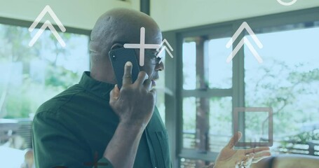 Animation of arrow and geometric shapes over senior biracial man talking on smartphone - Powered by Adobe