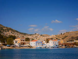 Fototapeta premium Symi Island, Greece. Greece islands holidays from Rhodos in Aegean Sea. Colorful neoclassical houses in bay of Symi. Holiday travel background.