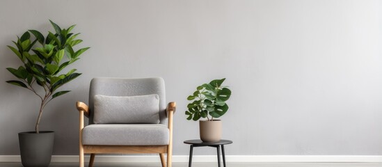 Armchair and table in living room with plant and poster