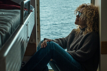 One woman passenger inside cabin boat cruise ferry having relax sitting near the window with ocean...