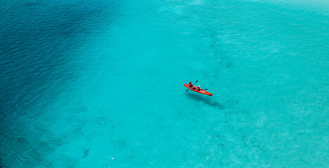 Aerial view of kayak with people in blue turquoise sea. Kayaking, leisure activities on the ocean....