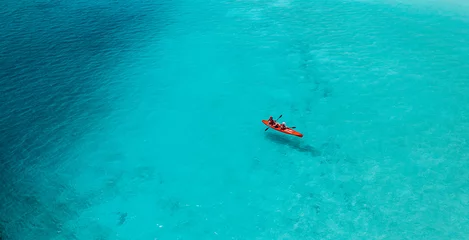 Foto op Canvas Aerial view of kayak with people in blue turquoise sea. Kayaking, leisure activities on the ocean. Active travel, outdoor exotic destination recreational water sport. Tropical ocean bay amazing scene © icemanphotos