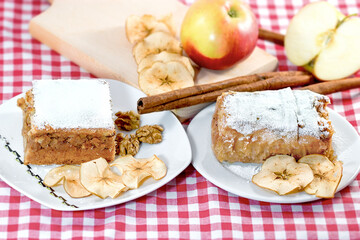 Apple strudel with cinnamon, apples and walnuts on the table - 658110095