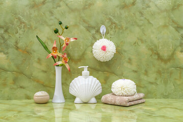 A set of bathroom accessories. Sponge, towel, dispenser with liquid soap. Body care.  Green marble background.