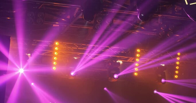 Pink orange spotlights in party club. Bright magenta color of professional spotlights shine on concert. Natural, real lighting show backdrop. Colorful light illumination in motion. Moving glow laser