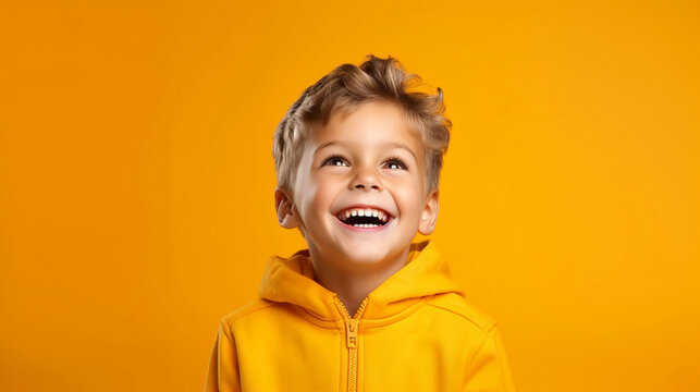 S&uuml;&szlig;er blonder Junge lacht mit einfarbigen Hintergrund