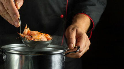 Cooking shrimp in a saucepan. The concept of delicious and healthy seafood. Boiled shrimps in a ladle in the chef hand. Copy space