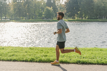 A jogging guy in sportswear and full-length running shoes. A man training alone is an active and healthy lifestyle motivation. Fitness every day for cardio tolerance.