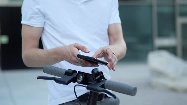 close up of a young businessman activating an e-scooter with his phone