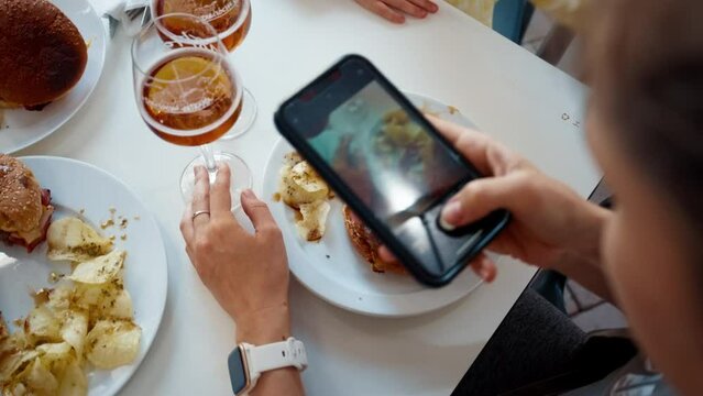 Blogger tourist photographing food in restaurant on smartphone on vacation trip