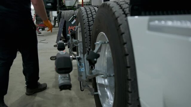 The mechanic alignment the wheels in truck stands on a alignment stand in a repair shop.