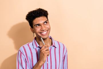 Portrait of thoughtful guy with piercing dressed stylish shirt dreamy look empty space pen on chin...