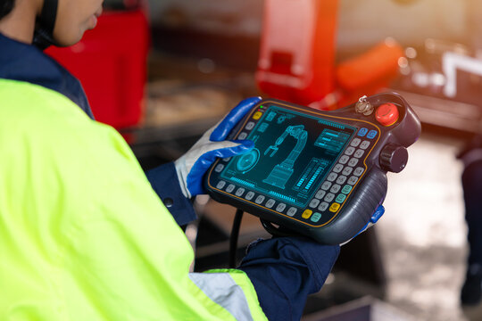 Smart engineer staff worker use digital remote control operate industry robot arm in automation factory technology engineering