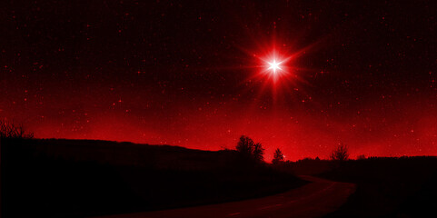 Bright red star shines over the road at night. Birth of Jesus concept, Star of Bethlehem - 658162410