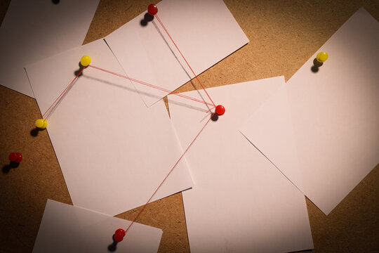 The papers are connected with threads on the board