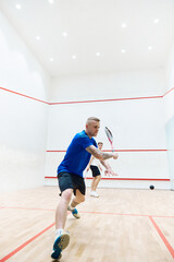 Activity. Young sportive guy in sportswear training, playing squash on squash court. Exercising. Concept of sport, hobby, healthy and active lifestyle, game, gym, ad