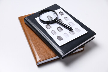 Books, magnifying glass with fingerprints on a white background