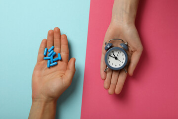 Viagra pills with clock in male hands