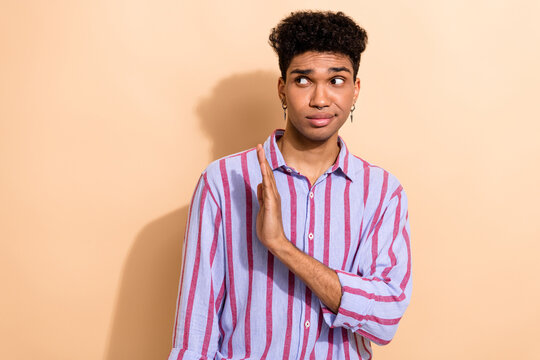 Portrait of serious young guy hold hand palm straight to empty space express negative attitude isolated beige color background