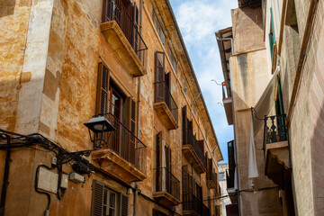 An idyllic scene of Palma de Mallorca old town, an empty narrow street lined with old facades, preserving the timeless charm of this Mediterranean gem. Balearic Islands Spain.