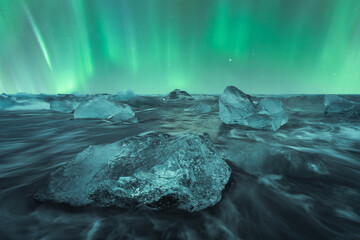 Broken ice floating in sea water on black beach in Iceland