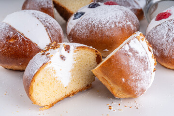 Homemade italian sweet Maritozzi buns, breakfast dessert brioche stuffed with whipped cream, with various topping, nuts, fruit 