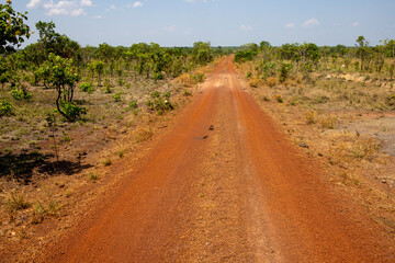 Aerial shot of a reddish dirt road through the remote Bolivian Pampa in the department Beni -...