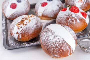 Homemade italian sweet Maritozzi buns, breakfast dessert brioche stuffed with whipped cream, with various topping, nuts, fruit 