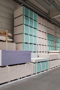 Warehouse with gypsum plasterboard sheets stacked on pallets.