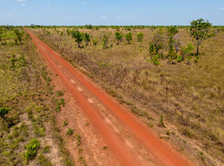 Aerial shot of a reddish dirt road through the remote Bolivian Pampa in the department Beni - Traveling and exploring South America