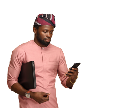 portrait of the African man in ethnic clothes. PNG of an a Nigerian man using his phone while holding his laptop - Powered by Adobe