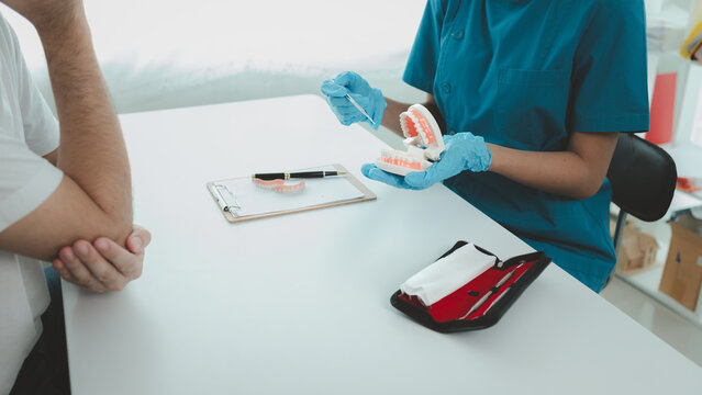 Man undergoes a dental checkup with professional dentist at dental clinic, undergoes a dental checkup with a professional dentist and receives oral care advice. Concept of receiving dental treatment.