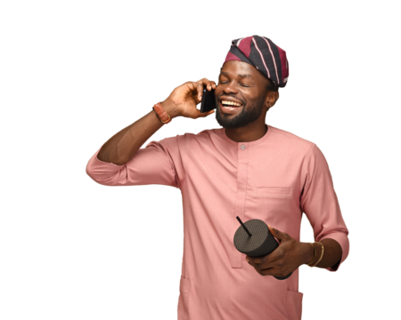 PNG Portrait of excited African American man talking happily on his smartphone whilst holding a cup isolated over brown studio background wall, copy space. A positive man excited making a phone call