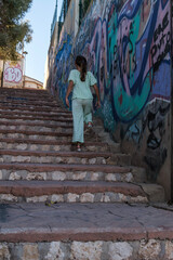 niña con vestido verde subiendo las escaleras de la calle