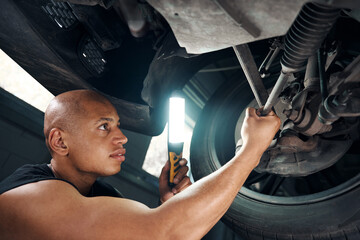 Auto mechanic checking condition of car running system after accident