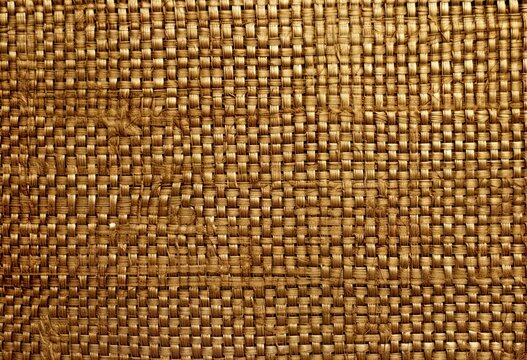 Gold weaved texture with irregular structures, details. Flat wicker basket weave texture, material background for luxury backdrop, card, banner. Antique, rough surface, textile, fabric.