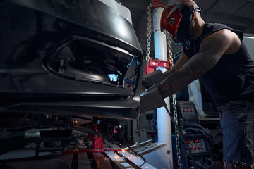 Auto-mechanic welding rusted and rotten car sills and fenders