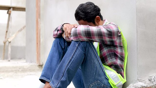 4K Asian foreman frustrated and hopeless worried unemployed or financial crisis lose a job, labor worker man relaxing after lunch break sitting on construction site, middle-age contractor male tried