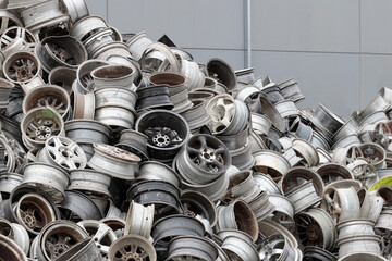 Scrapyard Closeup: Aluminum Rims for Recycling. Pile of old car rims at a scrapheap junkyard. - obrazy, fototapety, plakaty
