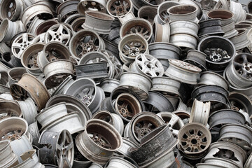 Scrapheap Junkyard with Old Car Rims. Closeup. Stack of old discarded wheels, metal recycling industry. - obrazy, fototapety, plakaty