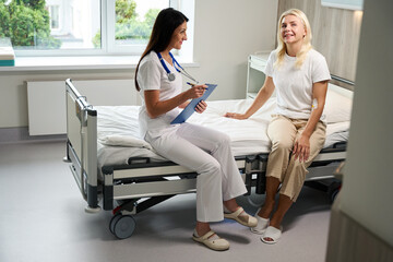 Attending physician communicates with a patient in a hospital ward