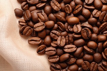 Roasted coffee beans in burlap sack. Coffee beans in bag, close-up top view.