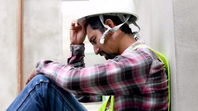 4K Asian foreman frustrated and hopeless worried unemployed or financial crisis lose a job, labor worker man relaxing after lunch break sitting on construction site, middle-age contractor male tried